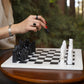 White and Black Marble Statue Chess Set Placing on the table and a women hand making move 